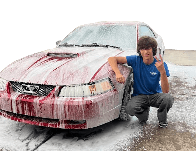 Clean Shine Detailing technician beside a car covered in fresh wash foam
